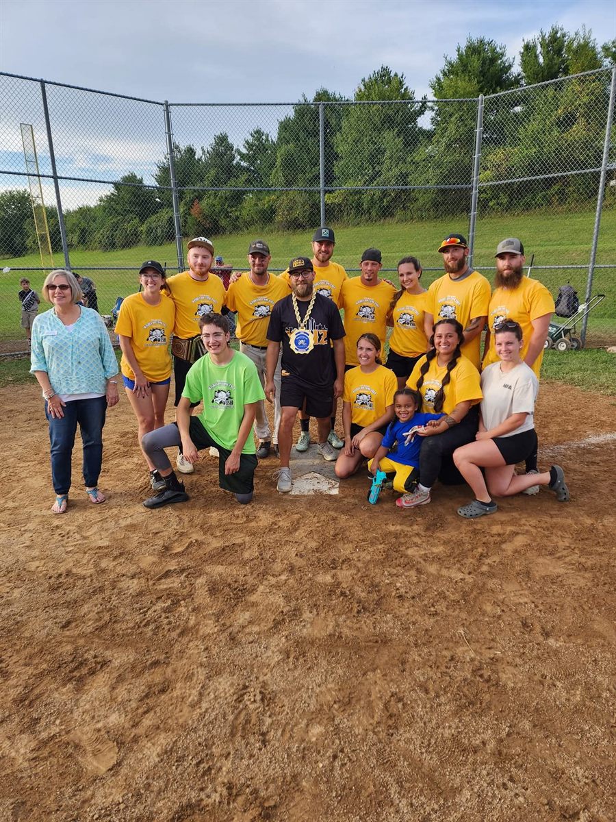 A championship team at the backstop, one player wearing the title belt