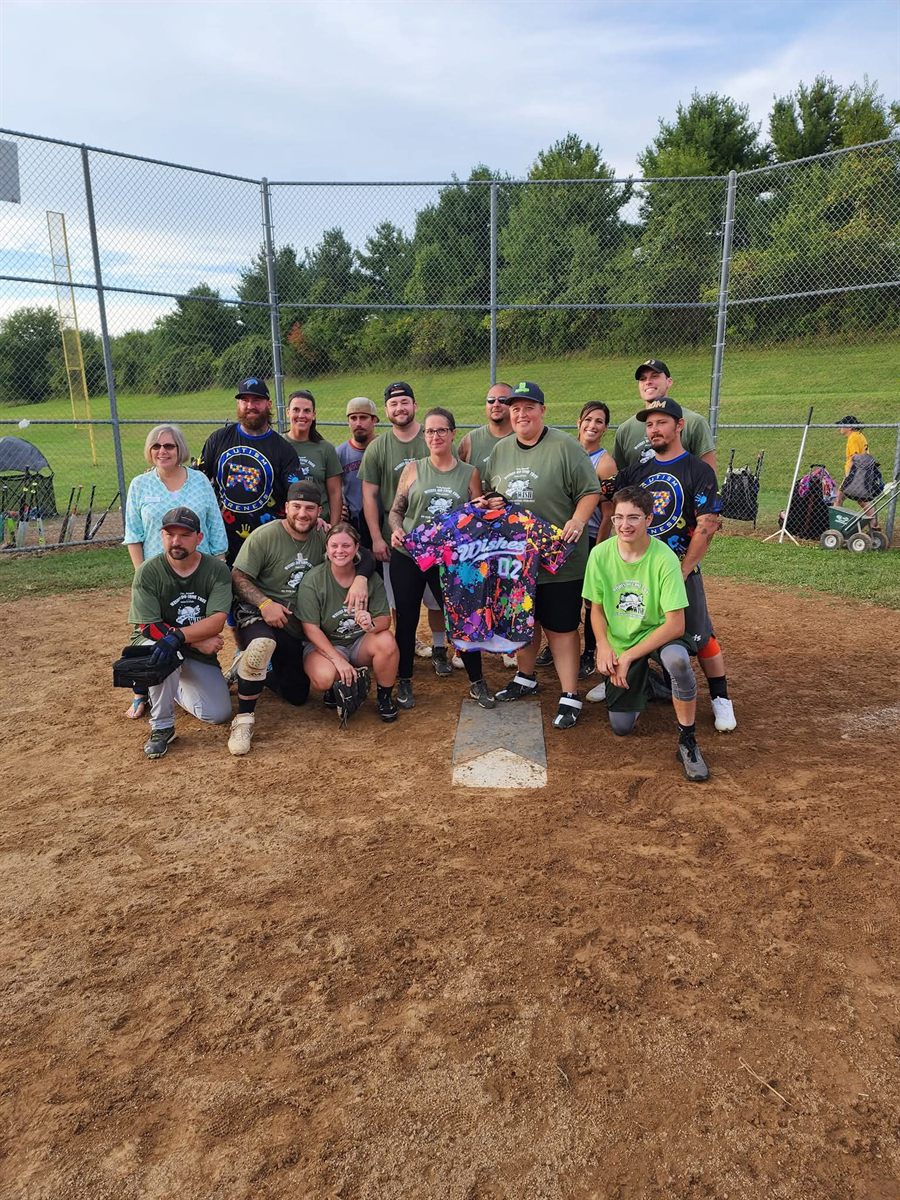 A team holding up a custom paint-splatter Wishes jersey