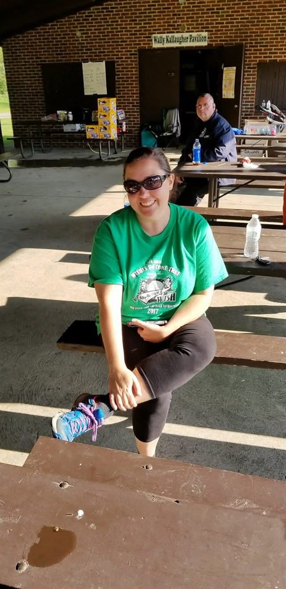 A smiling player at the pavilion in a tournament shirt