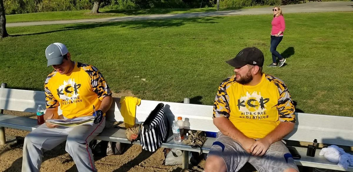 Two players in team jerseys on the bench between games